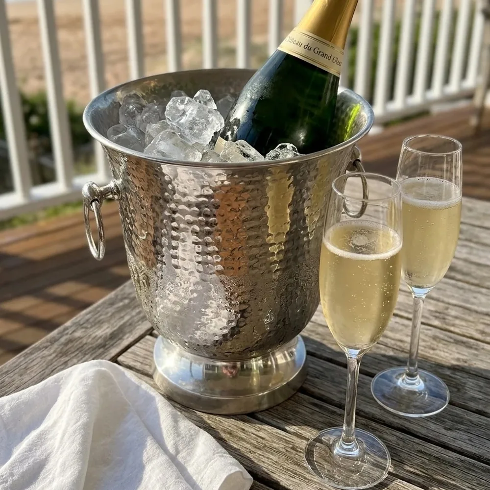 The Curl Curl ice bucket with a bottle of champagne on ice, on a beach house deck at Curl Curl